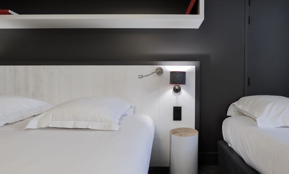 Lit double et lit simple dans une chambre triple avec murs gris