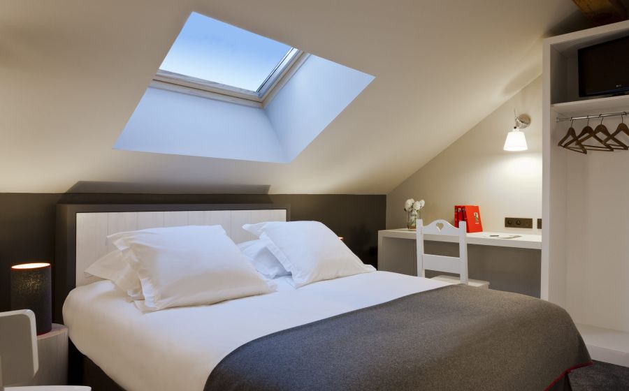 Woman reading on a white bed in a comfort bedrooms